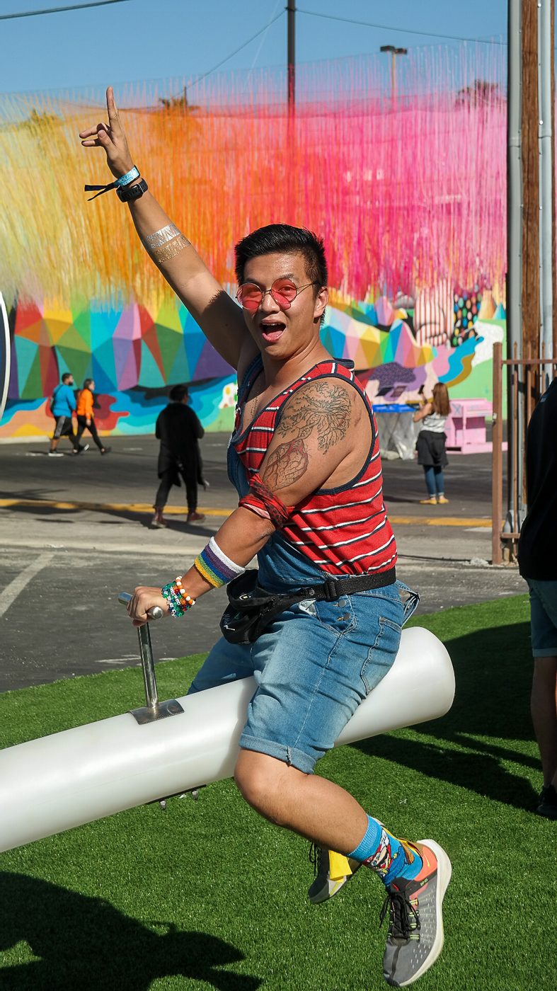 A guest mid-jump in front of a colourful outdoor art wall