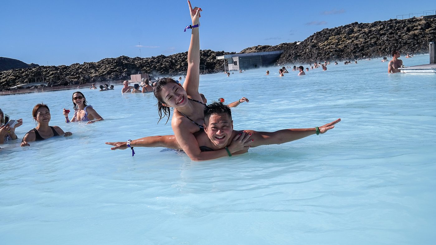 Two guests laughing together in a bright geothermal pool